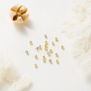 Macro detail of 18K gold plated brass spacer beads with faceted texture for DIY jewelry