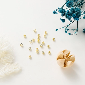 Macro shot of 18K gold plated copper spacer beads with intricate spiral floral engraving