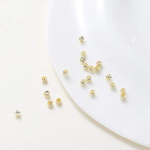 Macro detail of 18K gold plated copper beads with spiral textures for DIY jewelry
