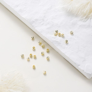 Macro shot of 18K gold plated copper beads with spiral texture for DIY jewelry making