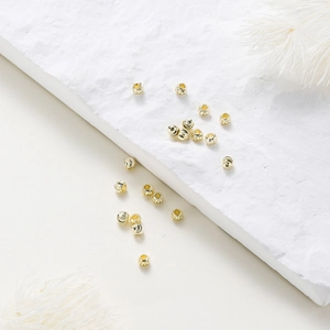 Detail of 18K gold plated copper beads with spiral engraved texture for jewelry making