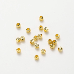 Detailed macro of 18K gold plated copper beads with spiral textures for DIY jewelry