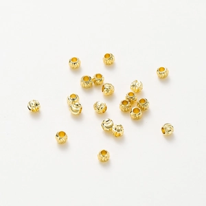 Close-up of 18K gold-plated copper beads with spiral texture for DIY jewelry making