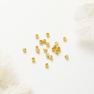 Detailed macro view of 18K gold plated copper spacer beads with spiral textured finish