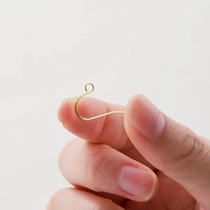 Hand holding high-quality 14K gold plated brass ear hooks for DIY jewelry making