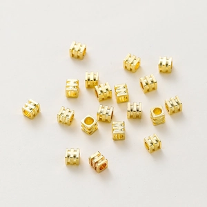 Detalle de cuentas espaciadoras de cubo de 4mm bañadas en oro 18K para joyería artesanal