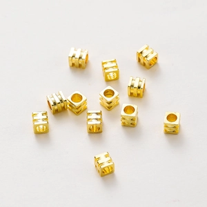 Vista macro de cuentas espaciadoras cuadradas huecas bañadas en oro 18K para joyas DIY