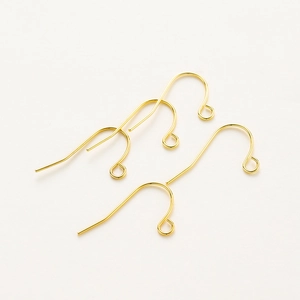 Close-up of four gold plated fish hook earrings with loop for DIY jewelry making