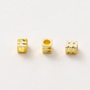 Detalle macro de cuentas espaciadoras cuadradas bañadas en oro de 18K para joyería DIY