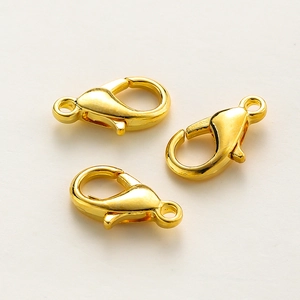 Close-up of three 18k gold-plated lobster clasps for jewelry making and necklace ends