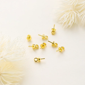 Detailed view of 18K gold plated pearl cup bails with peg and loop for jewelry making