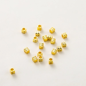 Primer plano de cuentas espaciadoras cuadradas bañadas en oro 18K para joyas DIY