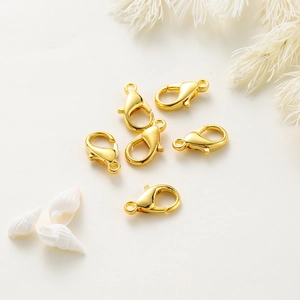 Polished 14k gold plated lobster clasps for DIY jewelry making on white decor