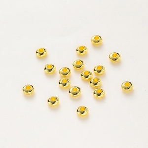 Macro shot of 18K gold-plated spacer beads with polished wheel shape for DIY jewelry