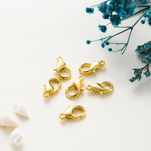 Close-up of six gold-plated lobster clasps for DIY jewelry making on a white background