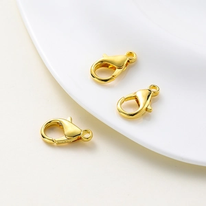 Detailed close-up of three polished 18k gold lobster clasps for necklace making
