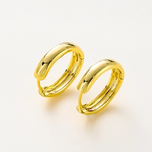 Detail of 14K gold plated chunky hoop earrings with a high-polished mirror finish surface