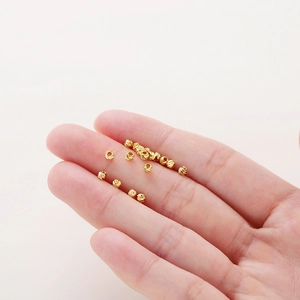 14K gold plated faceted spacer beads shown in a hand for jewelry making DIY