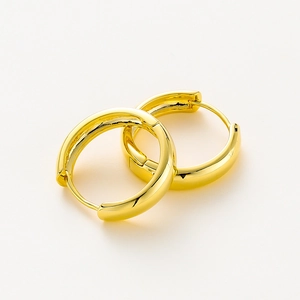 Detailed macro view of high-shine 14K gold plated chunky hoop earrings with hinged closure