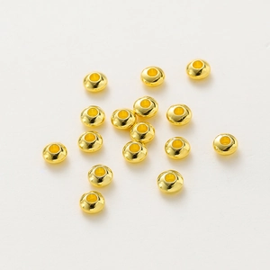 Macro view of polished 18K gold-plated rondelle spacer beads for DIY jewelry making