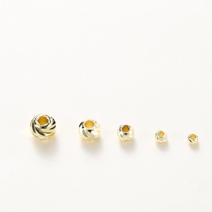 Detailed macro view of 14K gold plated faceted spacer beads in five varying size gradients