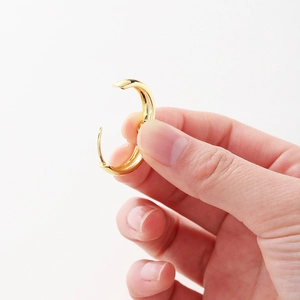 Detailed view of gold-plated C-shaped earrings showing the secure clasp and size
