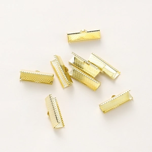 Close-up of golden plated ribbon crimp ends with textured surface for jewelry making