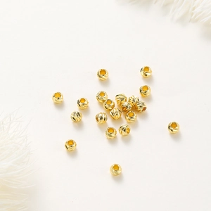 Macro view of 14K gold plated pumpkin spacer beads with detailed diamond cut texture