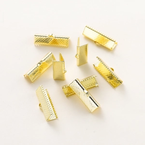 Close-up of gold-plated ribbon crimp ends with textured teeth for jewelry making