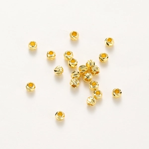 Macro shot of 14K gold plated pumpkin beads with faceted texture for jewelry making