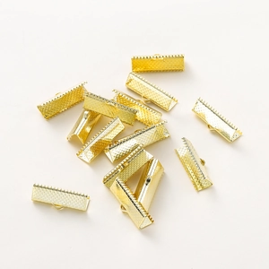 Macro detail of gold plated ribbon ends with textured surface and toothed metal clips