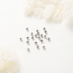 Macro shot of silver textured round spacer beads with spiral patterns for DIY jewelry making
