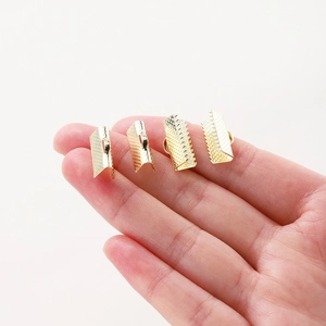18K gold-plated copper ribbon ends clips held on finger to show compact size