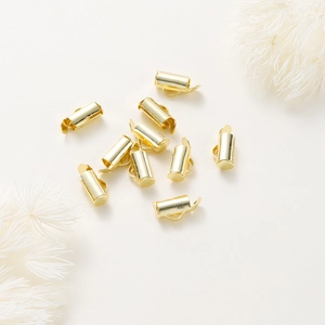 Primer plano de cierres deslizantes cilíndricos dorados para creación de joyería DIY