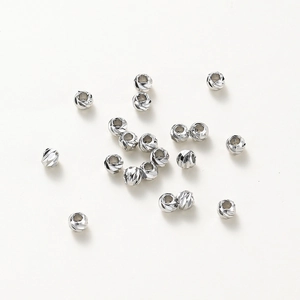 Close-up of faceted silver spacer beads with diamond-cut texture for DIY jewelry making