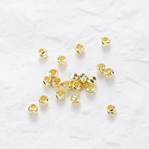 Macro detail of 14K gold plated faceted beads with spiral texture for DIY jewelry making