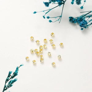 Macro detail of 14K gold plated textured spacer beads for DIY jewelry making crafts