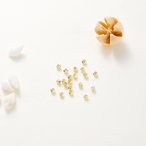 Detailed macro view of 14K gold plated pumpkin beads with spiral floral engraving for DIY jewelry