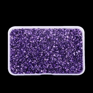 Detail view of irregular purple glass stones in a transparent box for DIY crafts