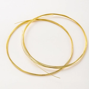 Macro shot of bright gold plated copper wire coil for DIY jewelry making and beading