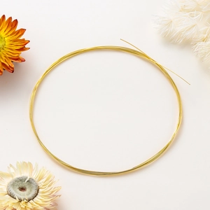 Close-up of bright 14K gold-filled beading wire coil for DIY jewelry making and necklaces