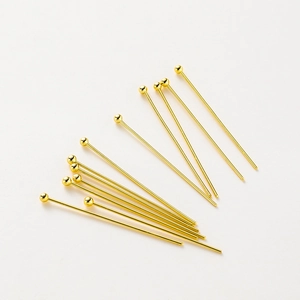 Macro detail of 14K gold plated ball head pins for professional DIY jewelry crafting
