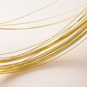Macro shot of gold-plated copper craft wire with glossy metallic finish for jewelry making