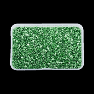 Macro shot of irregular green crystal stones for DIY crafts in a clear plastic container