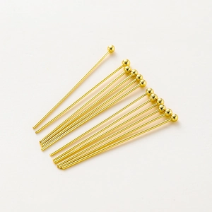 Detailed close-up of 14K gold-plated ball head pins for professional DIY jewelry making
