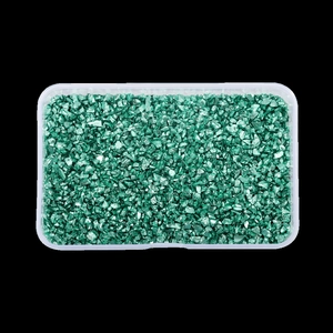 Macro shot of irregular metallic green glass shards in a clear plastic storage container