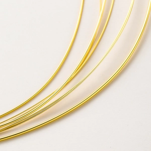 Macro shot of 14K gold plated jewelry wire showing glossy metallic finish and texture