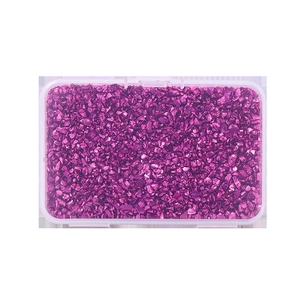 Detailed top view of bright purple metallic glass fragments in a clear plastic storage box