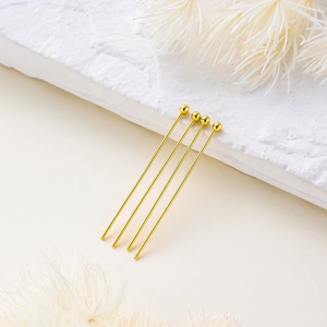 Detailed view of four 14K gold-plated ball head pins for professional DIY jewelry making
