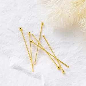 Macro view of 14K gold plated ball head pins for DIY jewelry making on white stone